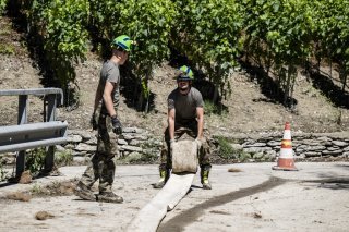 Deux militaires du bataillon d'intervention d'aide en cas de catastrophe, rangent le tuyau d'une pompe après une intervention sur la STEP de Noës